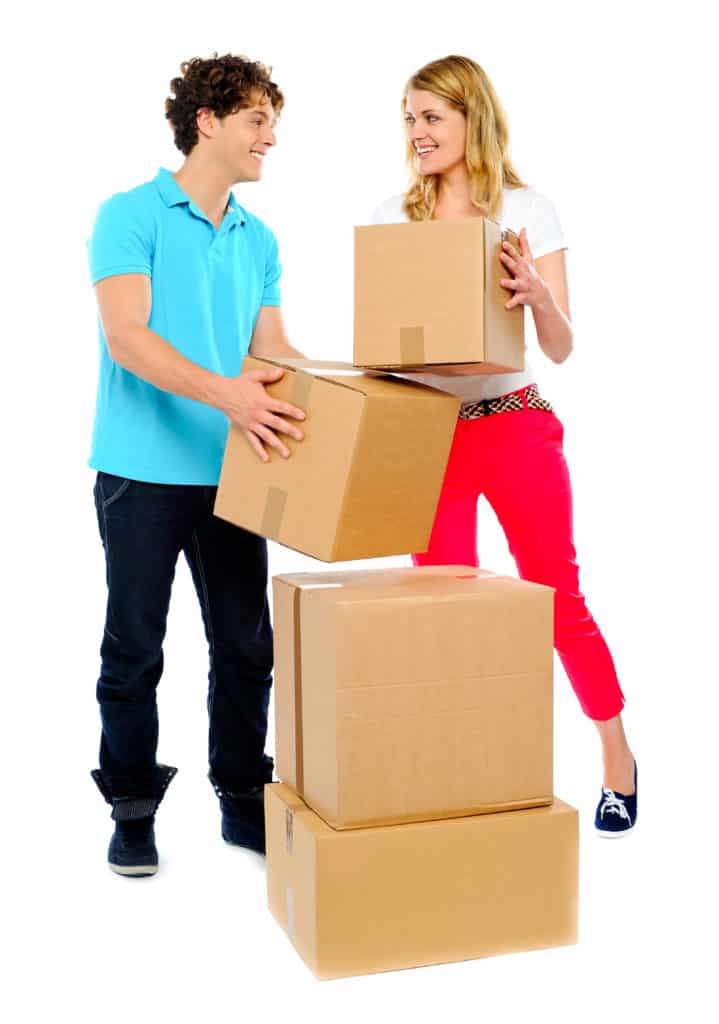 Happy young couple moving cardboard boxes smiling with eye contact